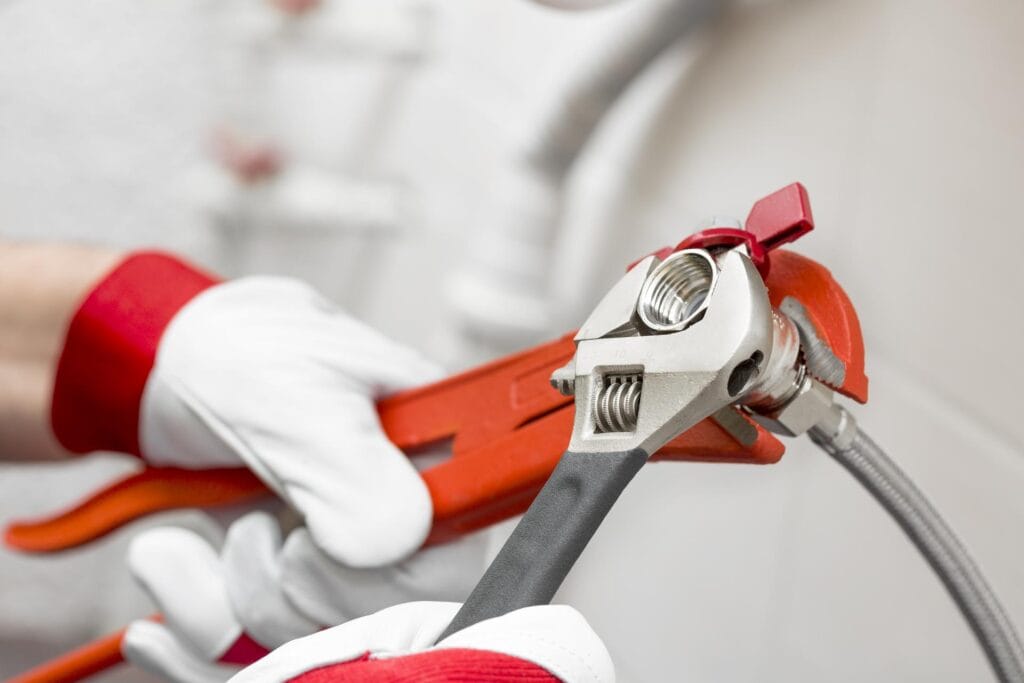 Plumber holding pipe wrenches for an emergency repair in Sebastian