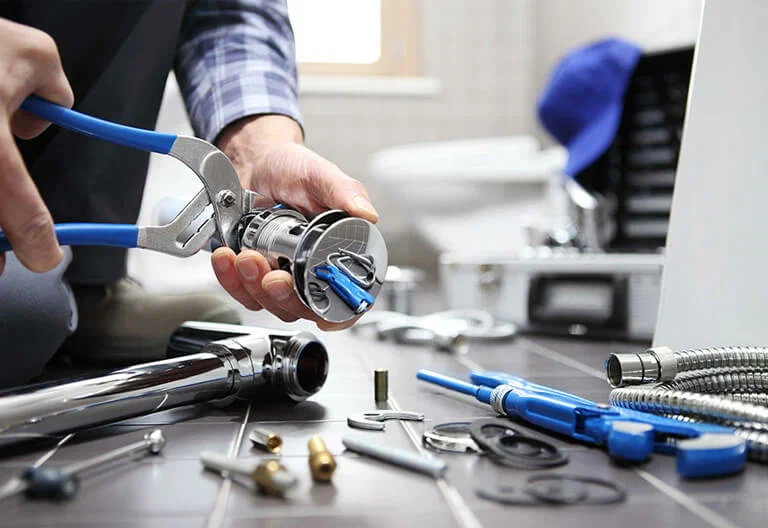 Technician repairing a plumbing fixture with professional tools in Sebastian