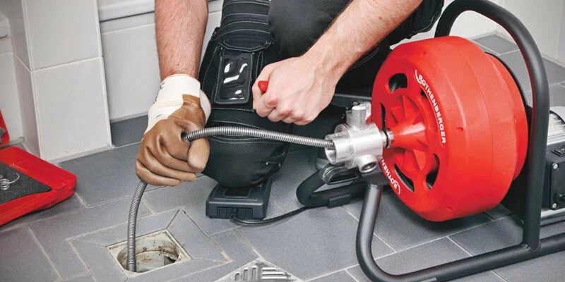 Plumber using a drain-cleaning machine in Sebastian