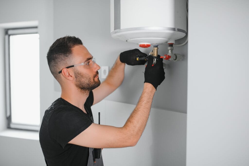 Technician performing water heater maintenance in Sebastian