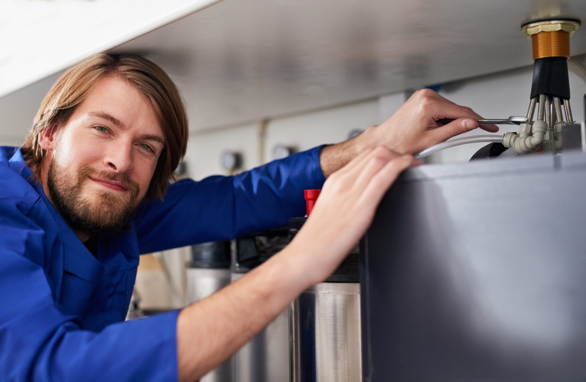 Technician servicing a residential water heater tank in Sebastian