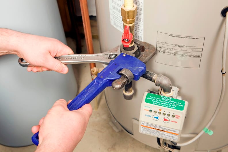 Plumber repairing a water heater valve in Sebastian
